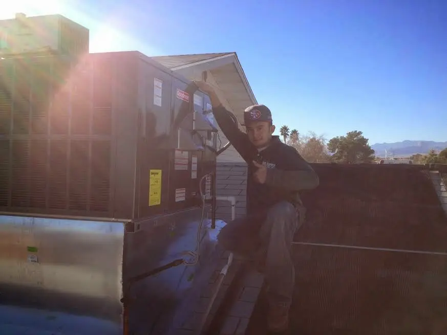 HVAC technician performing Air Duct Repair on a rooftop unit in West Lampeter