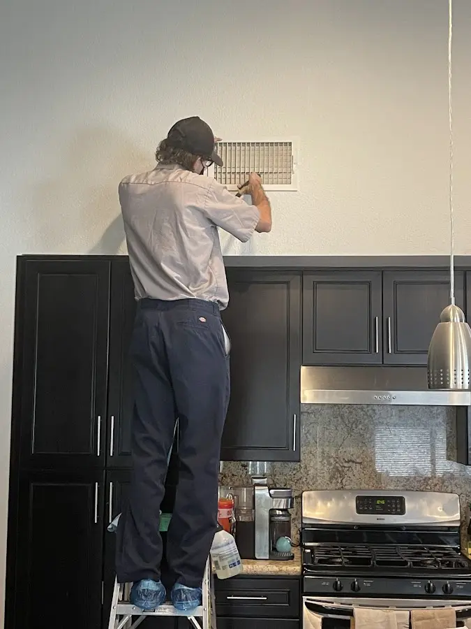 Technician inspecting an air vent during HVAC service in West Lampeter